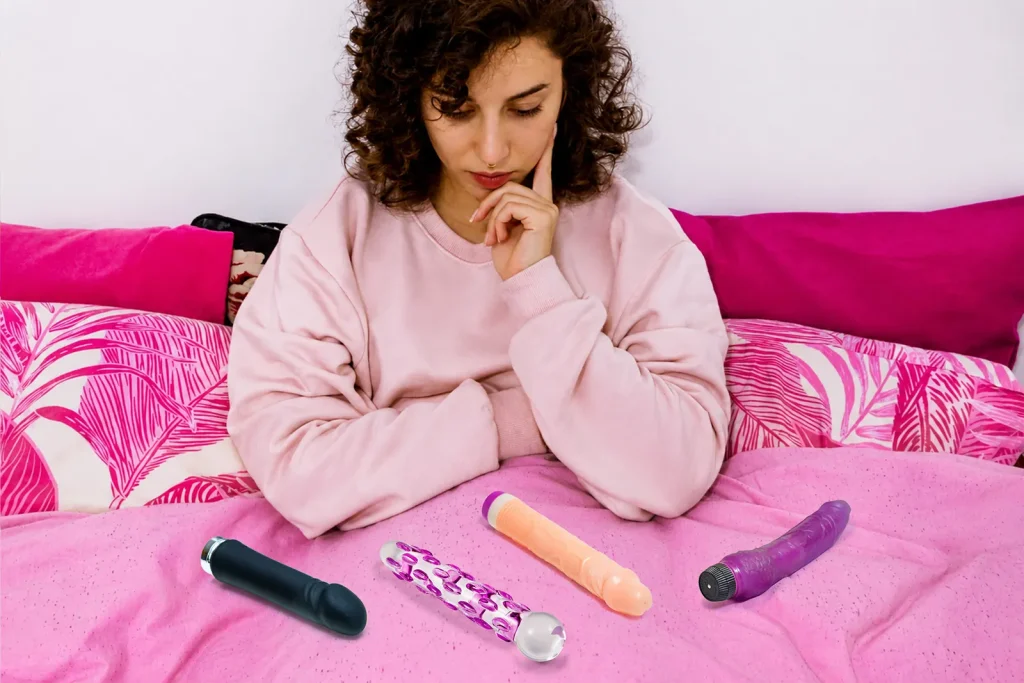 Comment choisir un gode : femme comparant plusieurs modèles avant de faire son choix