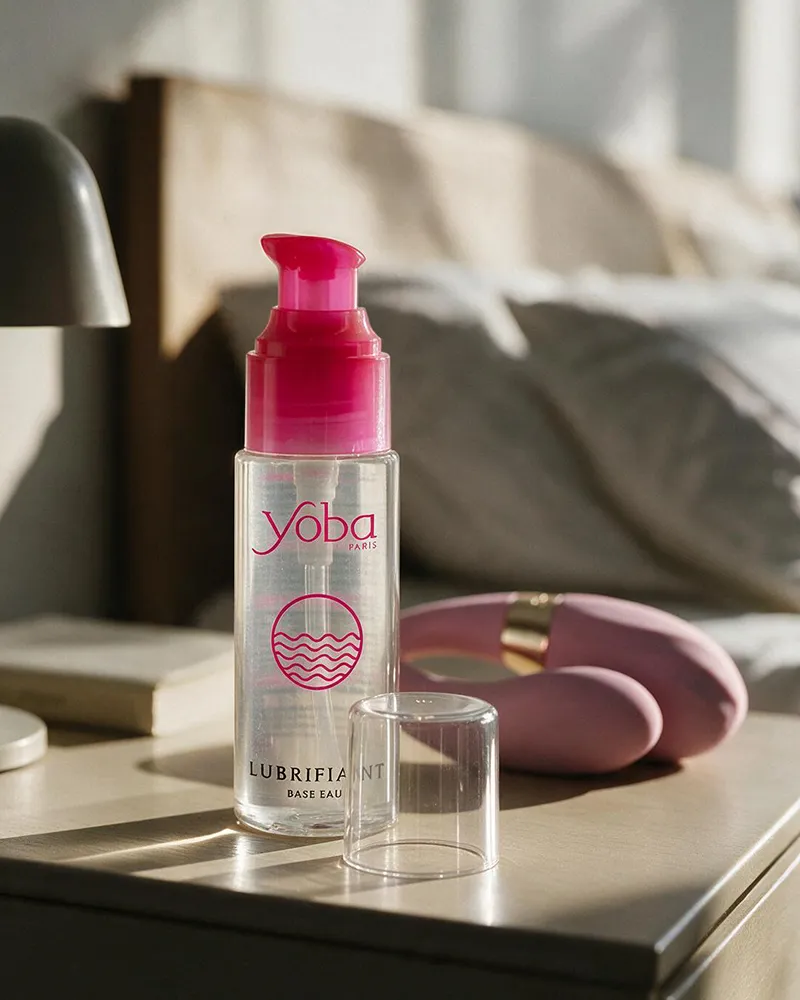 Lubrifiant intime à base d’eau Yoba avec un sextoy sur une table de chevet