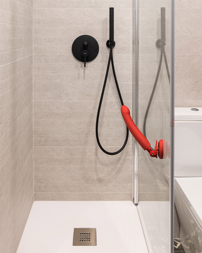 Gode ventouse rouge fixé sur la paroi vitrée d’une douche